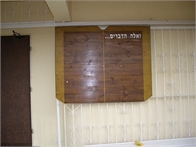 לוח מודעות מעוצב בצורת ספר לבית כנסת בבית עזרא